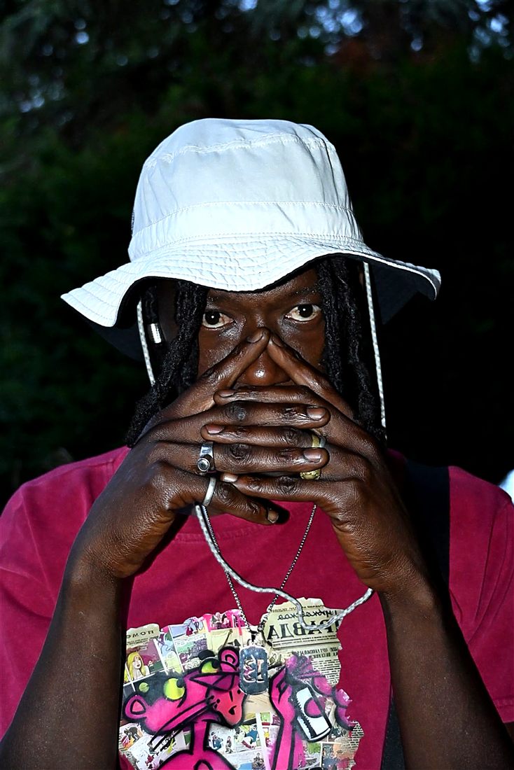 Faya Black, portrait au bob clair, mains croisées devant le visage